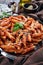 Italian penne arrabiata on a clay plate