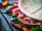 Italian piada wraps - piadina stuffed with fresh vegetable leaves and prosciutto ham on wooden table