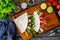 Italian piada wraps - piadina stuffed with fresh vegetables and roast chicken breast on wooden table, top view