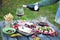 Italian picnic with red wine, parmesan, ham and olives. Lunch in the open air. Traditional snacks. A man pours a glass of wine.
