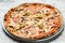 Italian pizza capriciosa mushroom artichokes, tomato and mozzarella cheese. Food recipe background. Close up