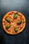 Italian pizza with cheese pepper basil vegetables on black background top