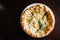 Italian pizza four cheese with arugula on a brown wooden desk background. Quattro FORMAGGI. from top. Delicious hot pizza on a