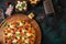 Italian pizza with ingredients. Mazzarella cheese, tomatoes. On a wooden board, on a dark green background. Top view with