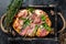 Italian Pizza with prosciutto parma ham, arugula salad and cheese in a rustic wooden tray. Black background. Top view