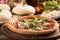 Italian Pizza with rocket salad on wooden table