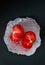 Italian ripe tomato with aluminium wrap on dark background