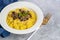 Italian risotto with champignons and parmesan on a gray background. Rice is seasoned with turmeric and herbs.