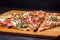 Italian rustic pizza, three pieces on a wooden tray, dark wooden table