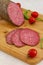 Italian salami on wooden background. Sliced beef salami. Close up