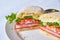 Italian sandwich classic cut in half parsley coated white plate plain background food dish meal