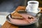 Italian traditional dessert cheesecake with walnut praline served on a pink plate with a cup of tea