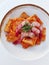 Italian traditional paccheri short pasta from gragnano with shrimps and burned onions cream