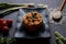 Italian vegan spring risotto on black dish with asparagus on dark background. healthy and fresh springtime vegetables like carrots