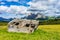 Italy, Alpe di Siusi, Seiser Alm with Sassolungo Langkofel Dolomite, an old barn in a field demolished