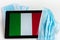 Italy flag covered by surgical protective mask for coronavirus COVID-19 prevention.