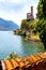 Italy, Lake Lugano. View of the lake, mountains and old houses and church, standing above the lake.