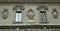 Italy, Milan, Via Farine, two windows and three blazons on the facade of the building