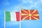 Italy and North Macedonia two flags on flagpoles and blue cloudy sky