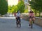 Italy relaxes lockdown to Phase Two. Two female teens biking in a park wearing protective masks Selective foreground focus