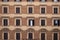 Italy, Rome. Wooden windows with brown shutters on a pastel color residential building facade, banner