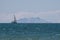 Italy Tuscany Maremma, on the beach Mouth of Ombrone, view of the island of Montecristo, passing sailing ship