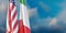 Italy and USA and relationship. US America and Italian flags on pole, cloudy sky