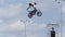 Italy - Verona, 05.14.2019: freestyle motorbike rider making breathtaking trick on blue cloudy sky background. Action