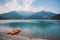 Italy view of a mountain lake lago di ledro with a beach and a lifeboat catamaran of red color in summer in cloudy weather