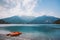 Italy view of a mountain lake lago di ledro with a beach and a lifeboat catamaran of red color in summer in cloudy weather