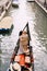 Italy wedding in Venice. A gondolier rolls a bride and groom in a classic wooden gondola along a narrow Venetian canal