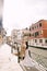 Italy wedding in Venice. Newlyweds stand embracing on the banks of the Venice Canal. The groom hugs the bride by the