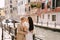 Italy wedding in Venice. Newlyweds stand embracing on the banks of the Venice Canal. The groom hugs the bride by the