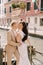 Italy wedding in Venice. Newlyweds stand embracing on the banks of the Venice Canal. The groom hugs the bride by the