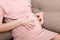 Itching woman is pregnant sitting on sofa at the home Skin problems and pores in teenagers