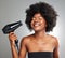 Itll be dry in no time. a young woman drying her hair against a grey background.