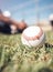 Its all about the ball. a baseball lying on a field during a match.