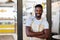 Its coffee oclock, step right in. Portrait of a handsome young man standing at the entrance to his coffee shop.