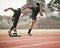 Its a head to head. Rearview shot of two unrecognizable young male athletes starting their race on a track.