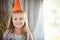Its not a party until youre wearing your party hat. Portrait of a happy little girl enjoying a birthday party at home.