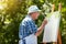 Its a painters dream. a senior man painting in the park.