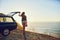 Its a view worth driving for. Rearview shot of a young woman standing next to her car during a roadtrip.