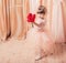 Ittle girl dressed as a ballerina in a tutu indoor