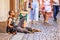 Ð¡ity landscape - view of a beggar sitting on a stone pavement in the Old Town of Prague