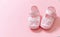 Itâ€™s a girl announcement. Baby girl pink shoes on pink color background. Baby shower, christening concept