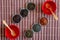 Ivan tea, rooibos marrakech, black tea, green tea and wooden spoons in red bowls on a brown bamboo mat, top view