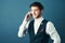 Ive been meaning to call you...Studio shot of a handsome young businessman making a phonecall against a blue background.