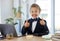 Ive got this. an adorable little girl dressed as a businessperson sitting alone in an office and showing a thumbs up.