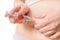 IVF and artificial insemination concept. Woman is injecting hormones to belly with syringe