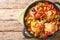 Ivory Coast food Chicken slowly stewed with vegetables and herbs close-up in a frying pan. Horizontal top view